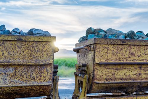 Free Rustic rail carts filled with rocks at sunset, showcasing vintage mining machinery. Stock Photo