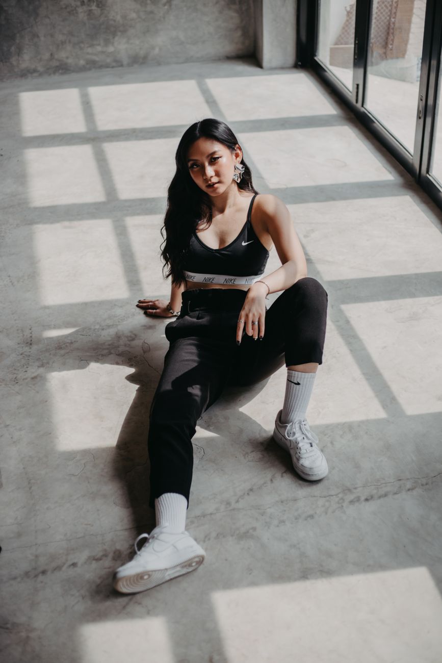 A woman in activewear sitting on a sunlit floor, the familiar soft-focus image that wellness branding leans on.