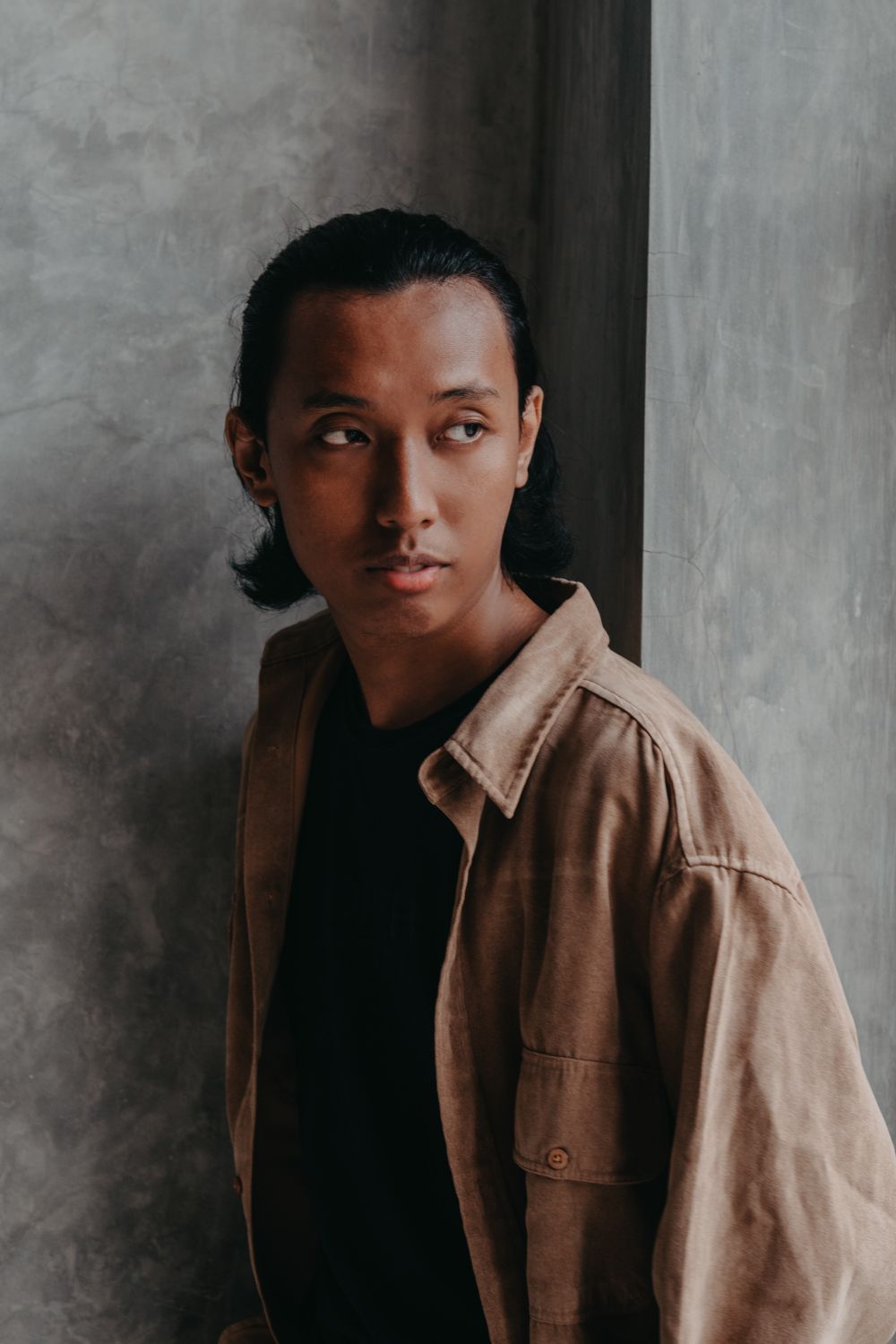 Man in a brown button-front overshirt layered over a dark T-shirt.