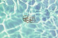 Close-up of elegant rings with a reflective water background, artistic composition.
