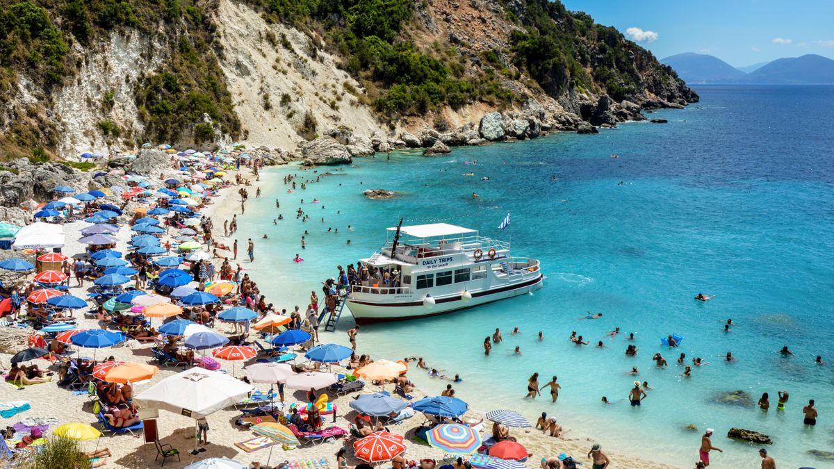 Plaja cu umbrele si un feribot pe coasta Lefkadei