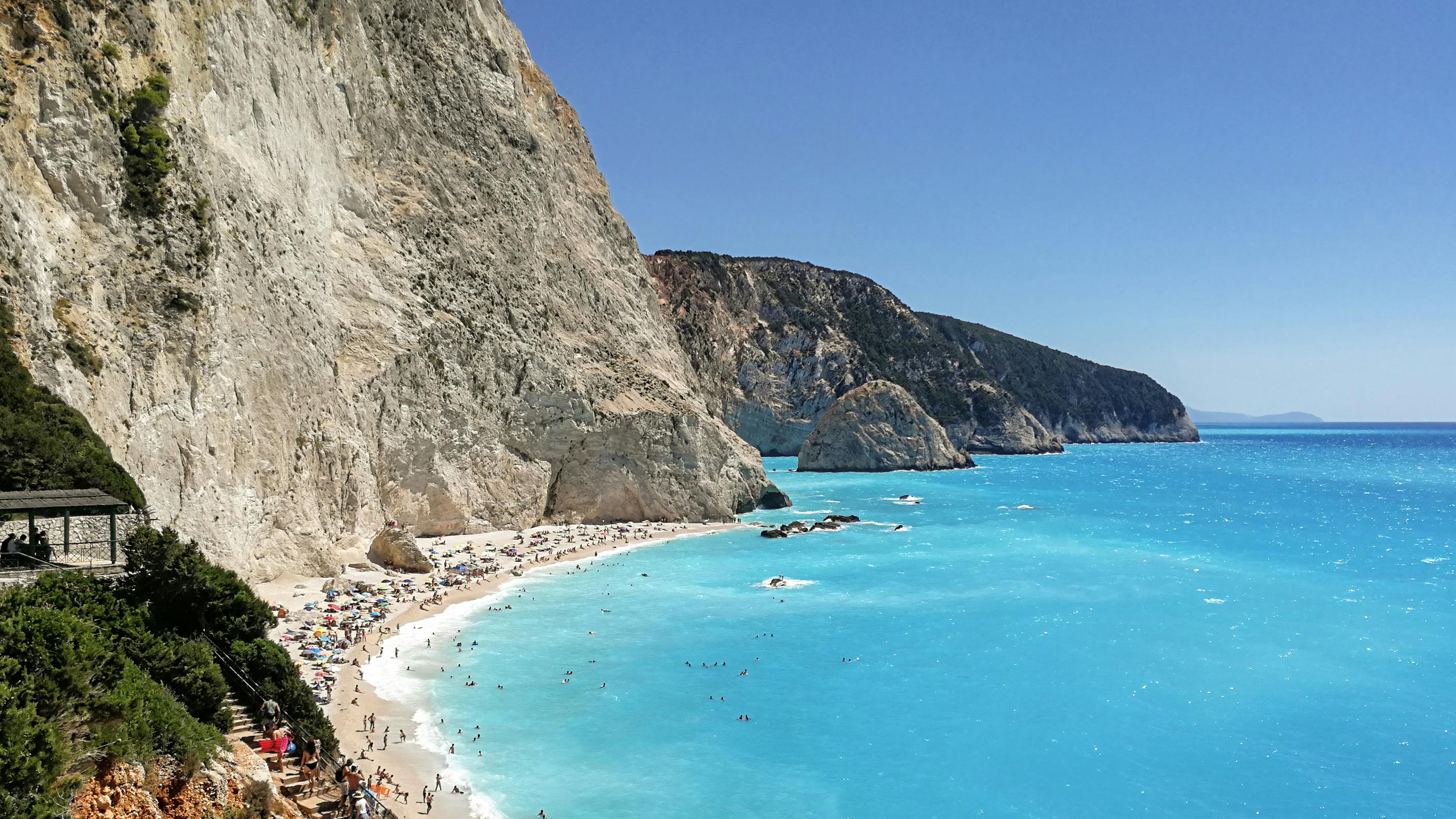 Aerial Photography of People on the Beach near Mountains and Blue Ocean