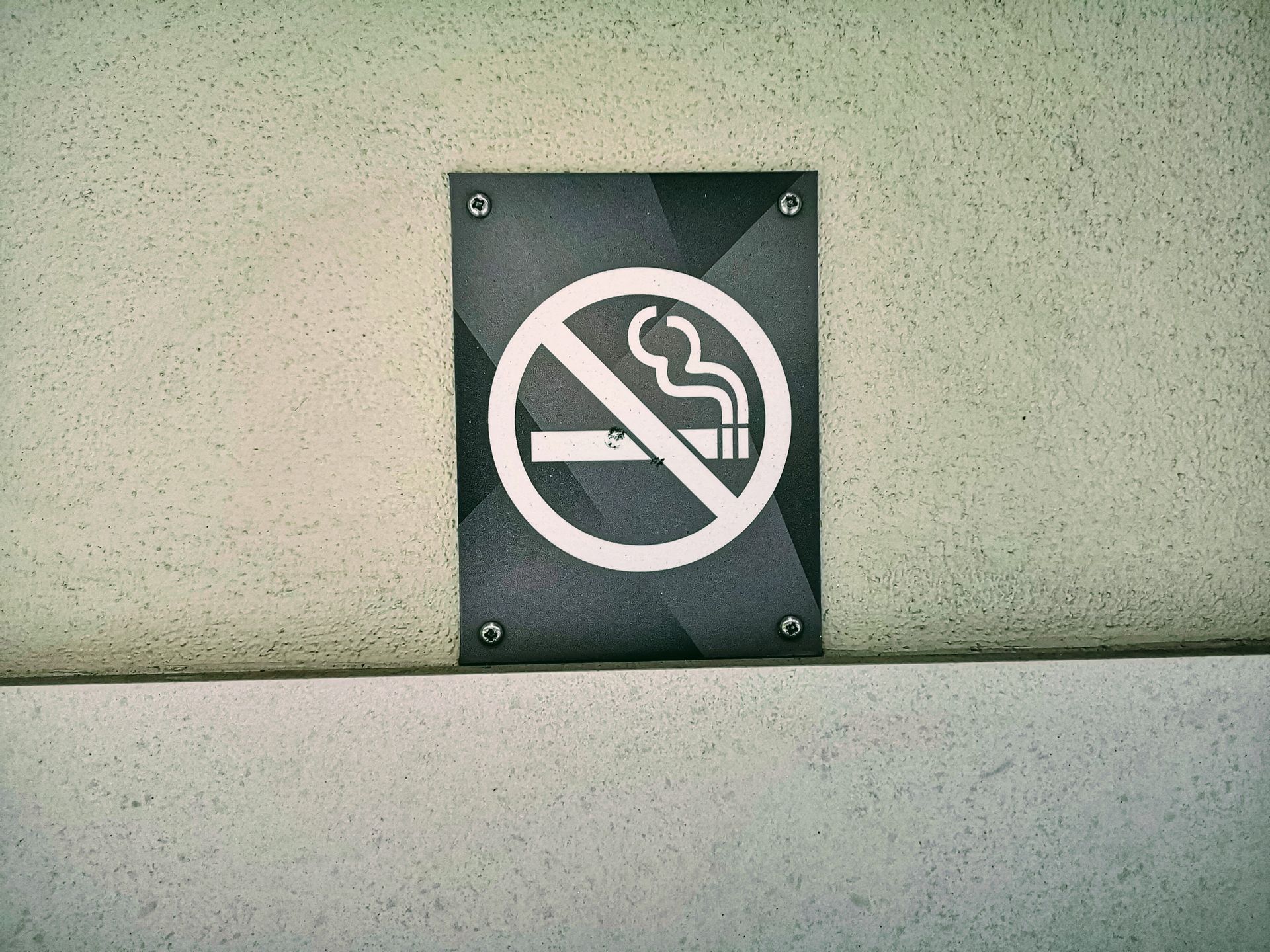 No smoking sign prominently displayed on a textured wall in London, England. Perfect for public safety themes.