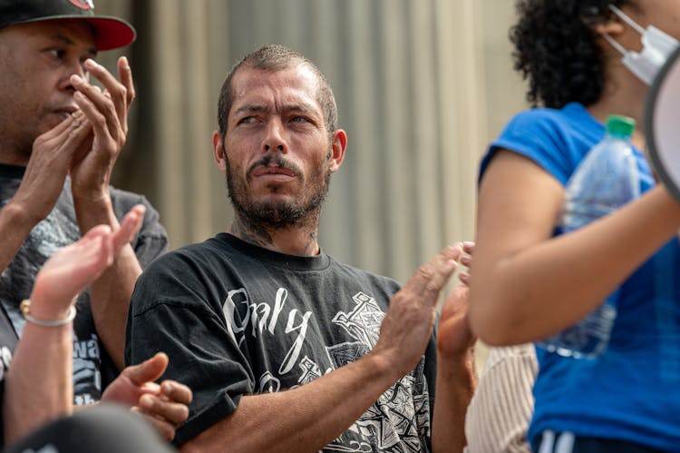 Thoughtful Man Clapping On Street During Demonstration