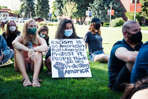 Young activists with banner protesting against discrimination in city park