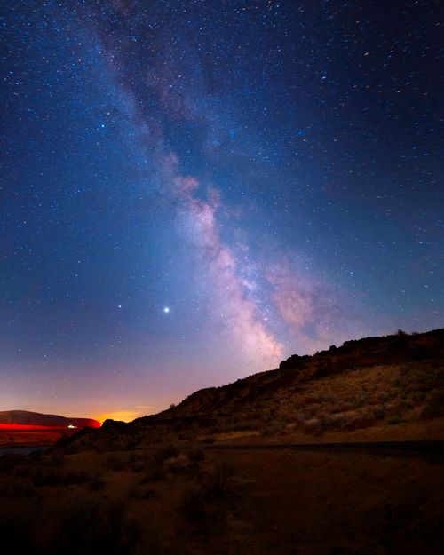Free Beautiful Milky Way galaxy above scenic desert landscape at night, offering a breathtaking view of the stars. Stock Photo