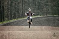 Man in Blue and White Jacket Riding Bicycle on Road