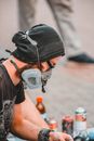 Man in Black Knit Cap and Black T-shirt Wearing Gray Gas Mask