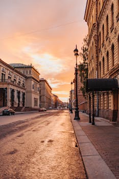 Beautiful sunset over a quiet city street with historic buildings and warm sky.