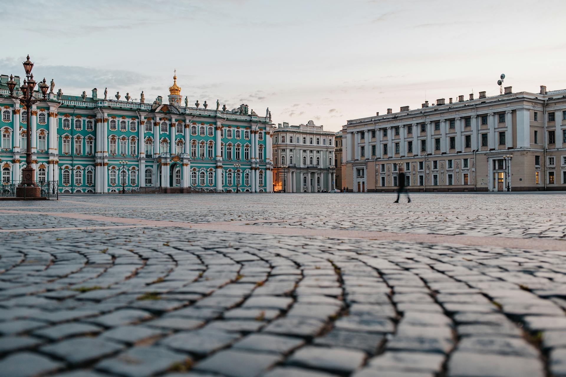 A Person Walking on the Cobblestone Street Near Palace Square