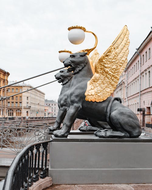 Statues on Bank Bridge Near City Buildings