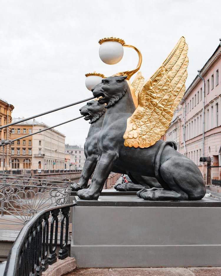 Statues On Bank Bridge Near City Buildings