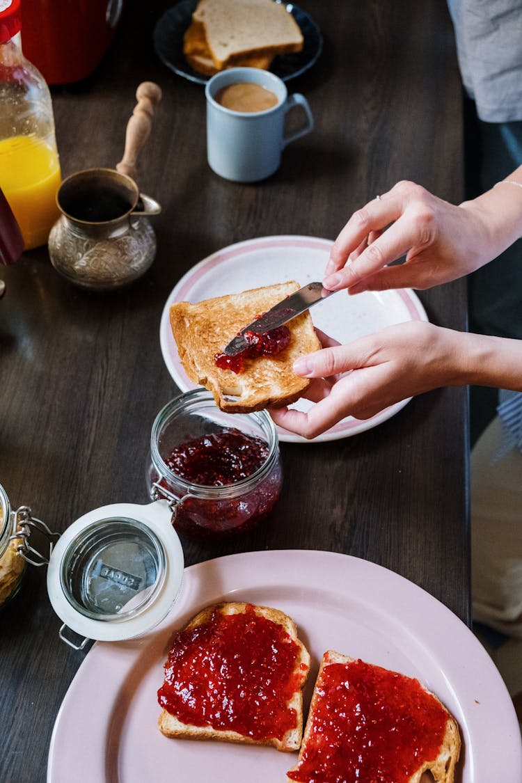 Person Spreading Jam On Toast 