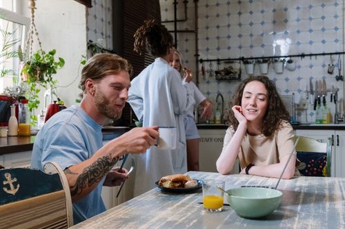 Free A group of friends enjoying a relaxed breakfast in a bright kitchen setting. Stock Photo