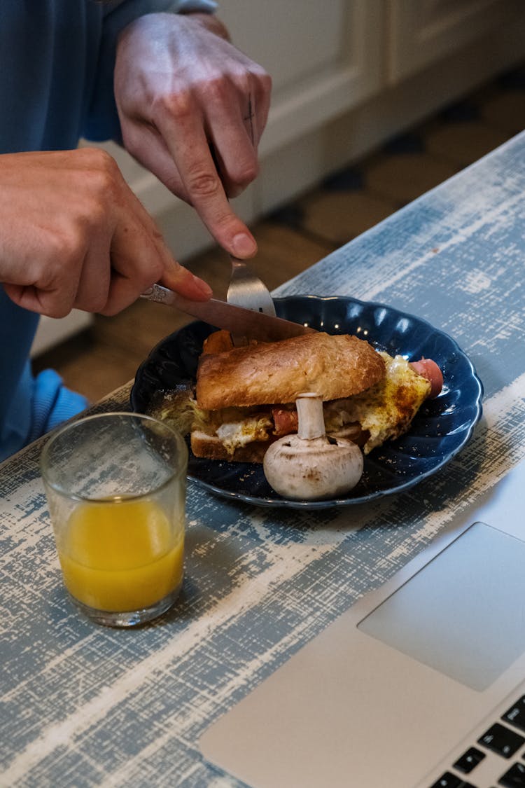 Person Cutting Food On C¥Blue Ceramic Plate