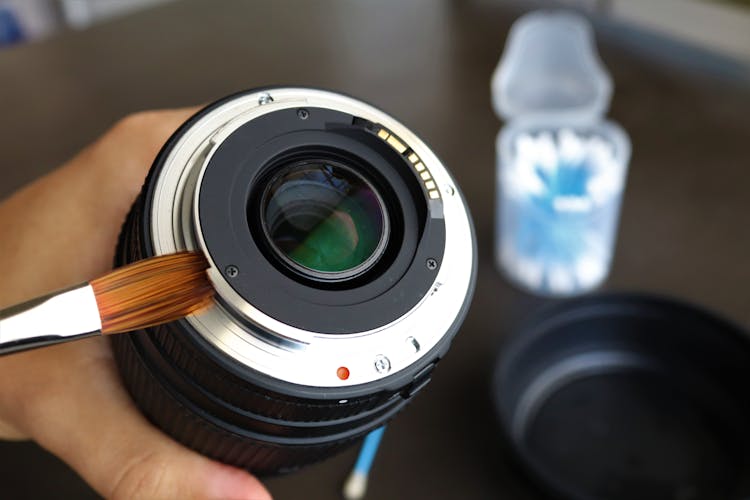 Person Cleaning Camera Lens