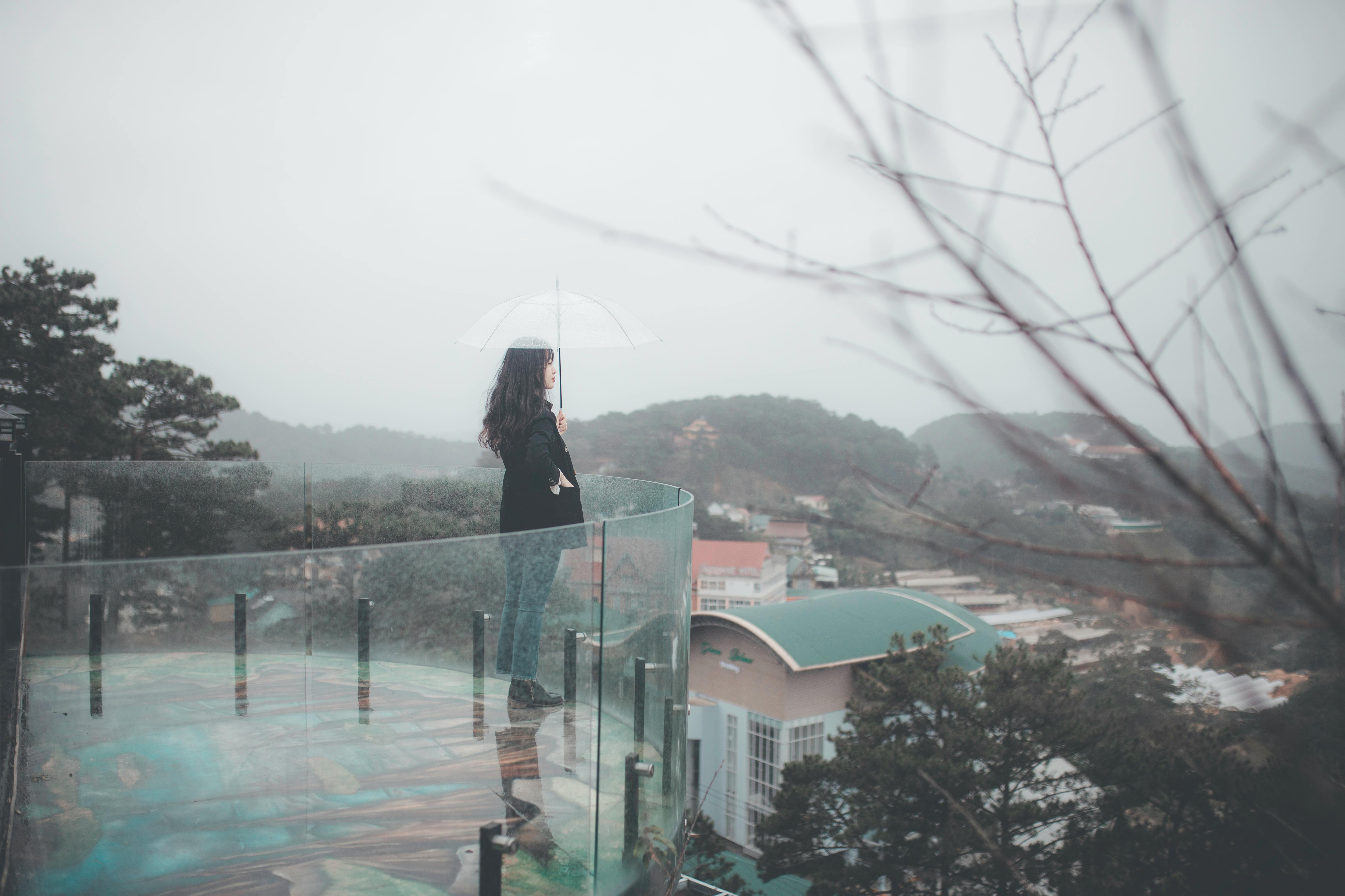 Balkon z szarymi deskami kompozytowymi ułożonymi na legarach, przy ścianie z cegły