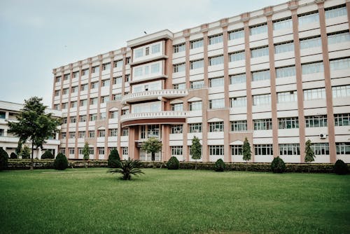 Brown Concrete Building With Green Grass Lawn