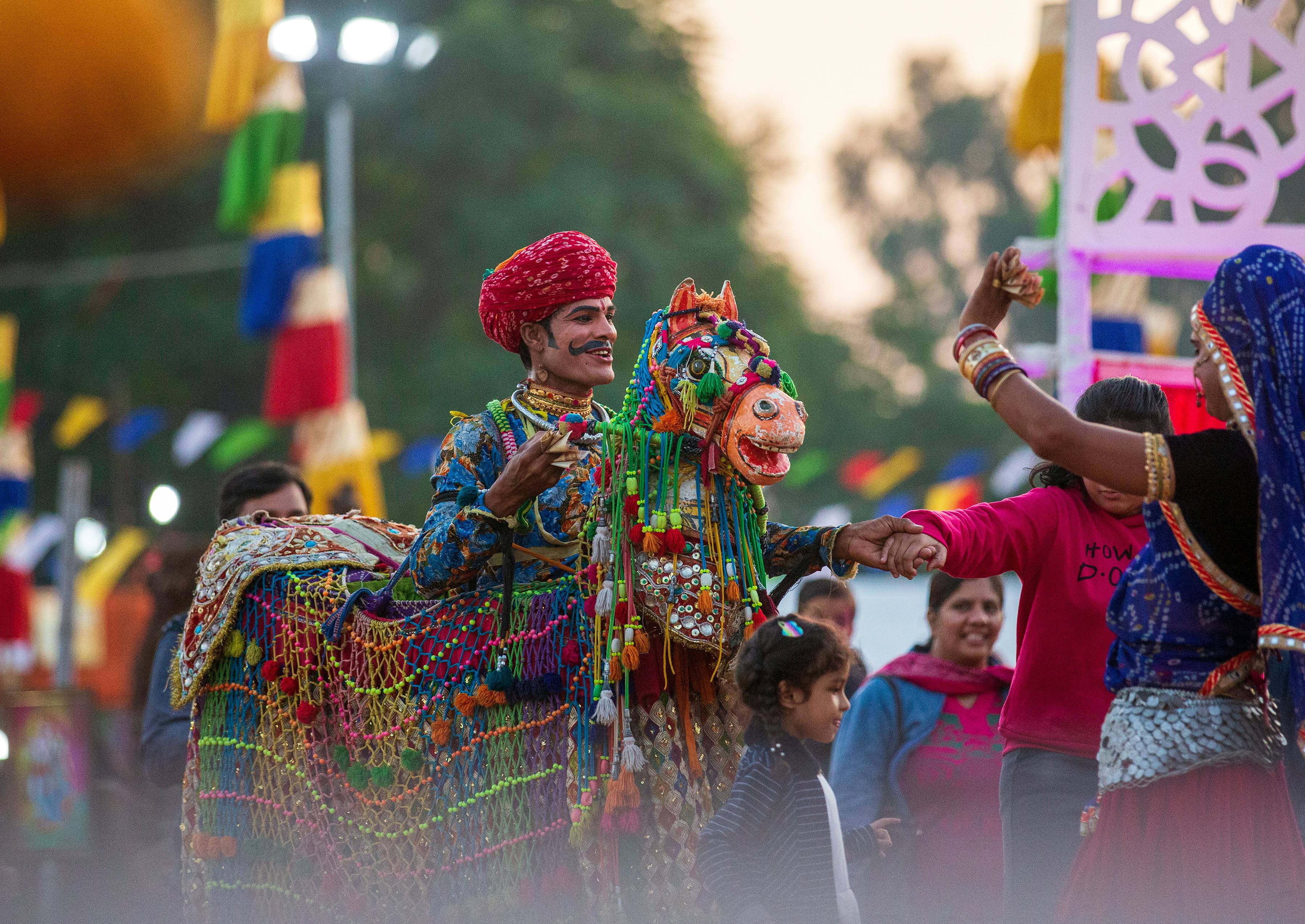 पगड़ी वाला आदमी रंग बिरंगी पोशाक में नाचते हुए 