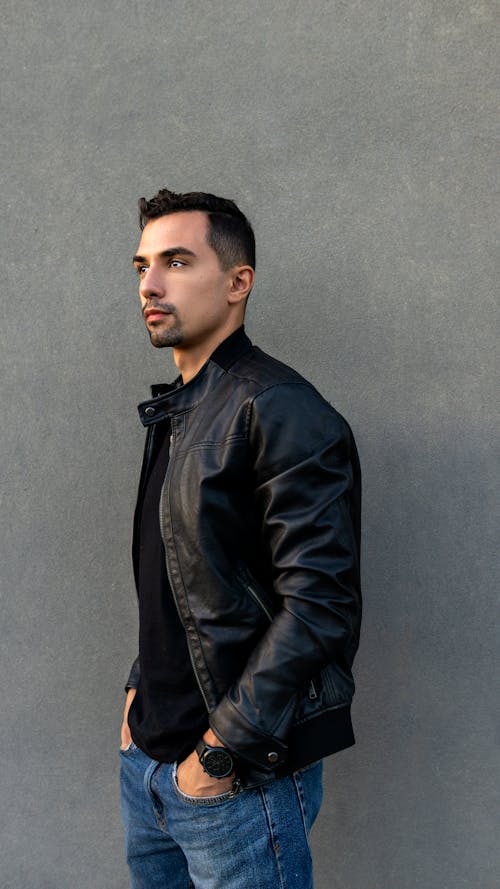 Man in Black Leather Jacket Standing Near Concrete Wall