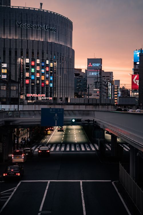 Free Vibrant nightlife at Yodobashi Umeda, Osaka captured at twilight, showcasing urban architecture and lively streets. Stock Photo