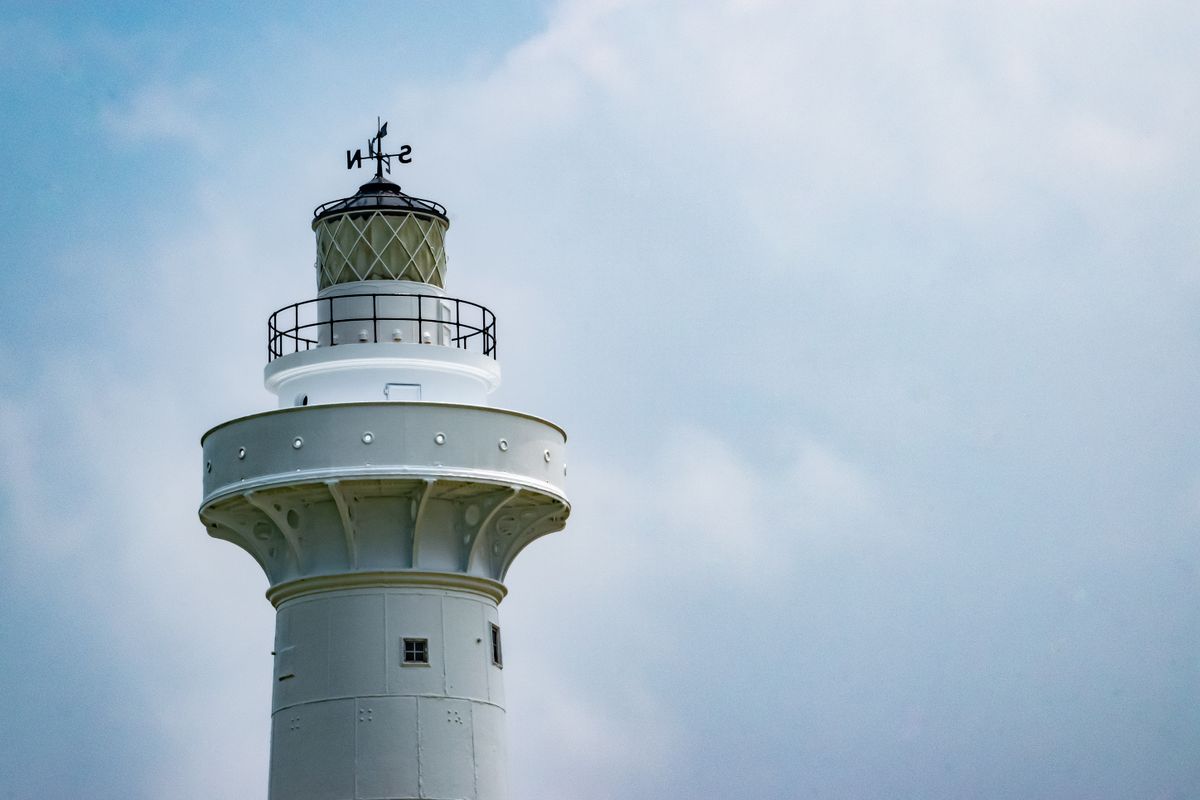 Eluanbi Lighthouse, white tower against a pale sky at Taiwan's southernmost point.