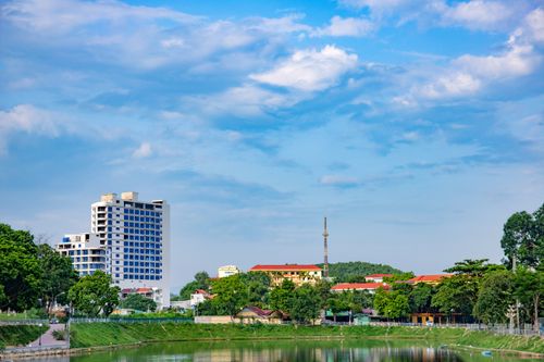Free High-rise building near a park with a vibrant sky creates a harmonious urban landscape. Stock Photo