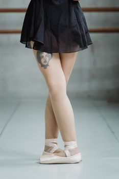 在舞蹈室里，芭蕾舞演员穿着带有纹身的尖头鞋，优雅地摆着姿势