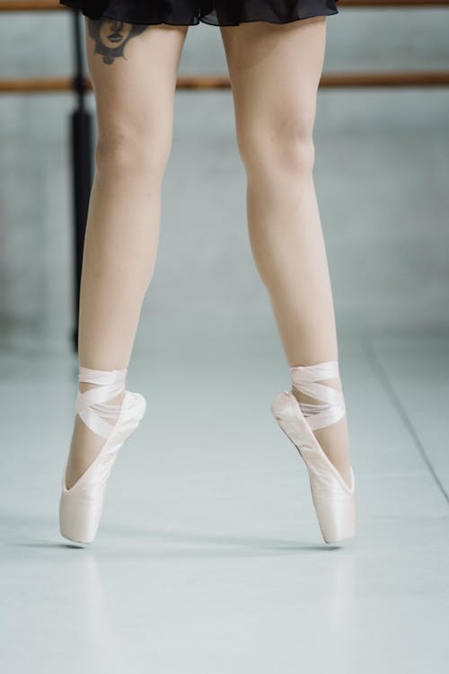 Free Crop faceless ballerina tiptoeing in ballet school Stock Photo