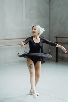 一位活泼优雅的女芭蕾舞演员在空荡荡的工作室里旋转