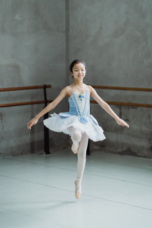 Free Graceful ballerina jumping on tiptoes in ballet class Stock Photo