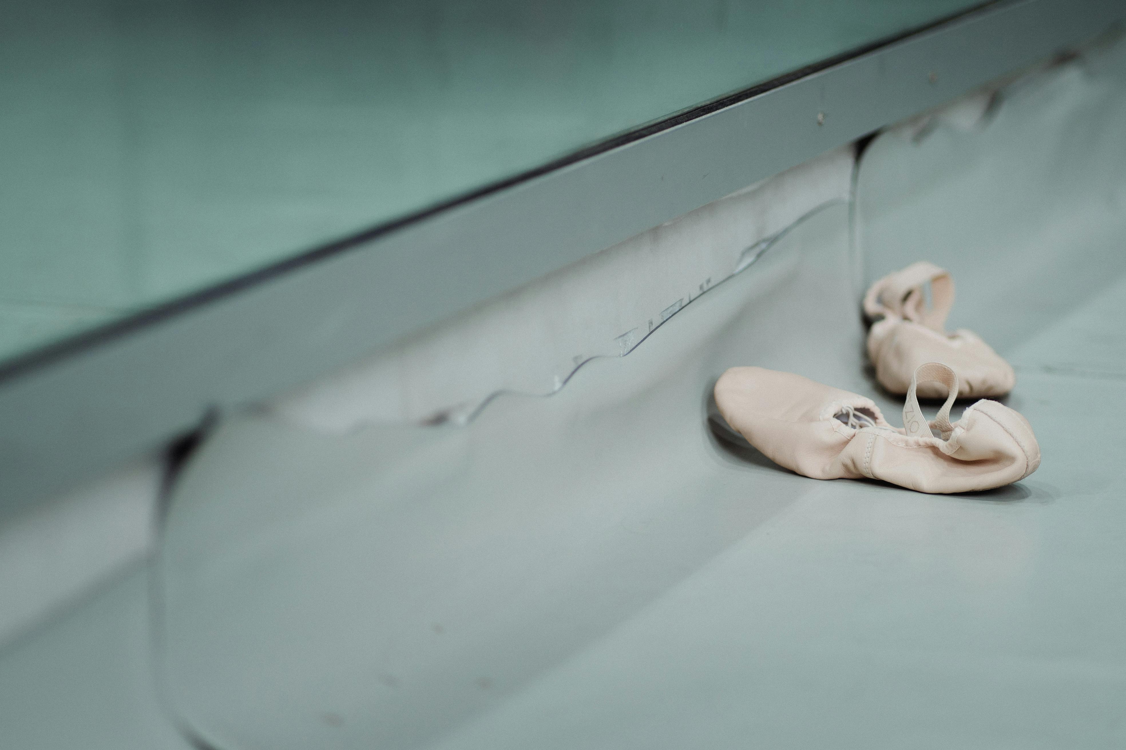 pointe shoes placed on floor in dance room