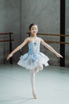 在明亮的工作室里，一位年轻的芭蕾舞演员正优雅地练习着