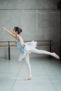 Graceful ballerina practicing Arabesque balance exercise in ballet studio