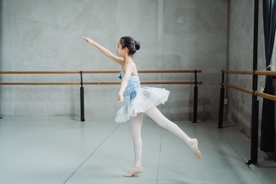 Graceful ballerina practicing Arabesque balance exercise in ballet ...