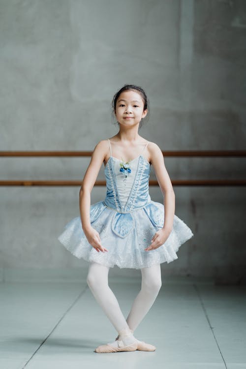 Free Smiling Asian ballerina girl performing plie in ballet school Stock Photo