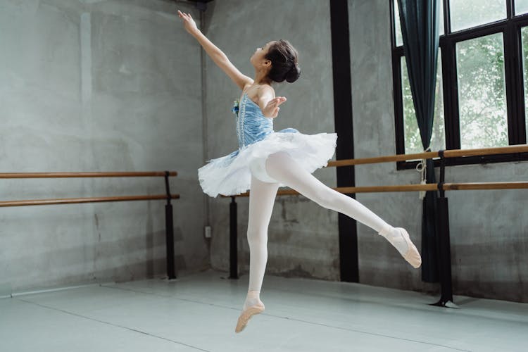 Ballerina Girl Performing Ballet Jump In Studio