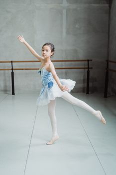 工作室里，一位灵活的民族芭蕾舞艺术家正侧身蹑脚起舞的全身图