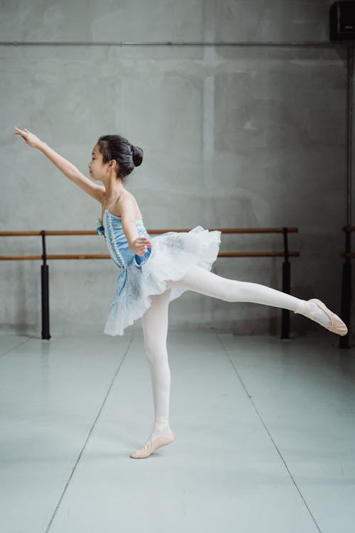 Ballerina stretching body in ballet studio