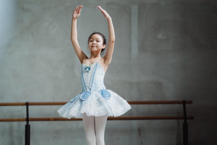 Graceful Ethnic Little Ballerina Dancing In Studio