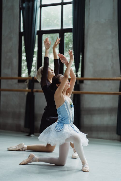 Graceful girl learning ballet dance with trainer