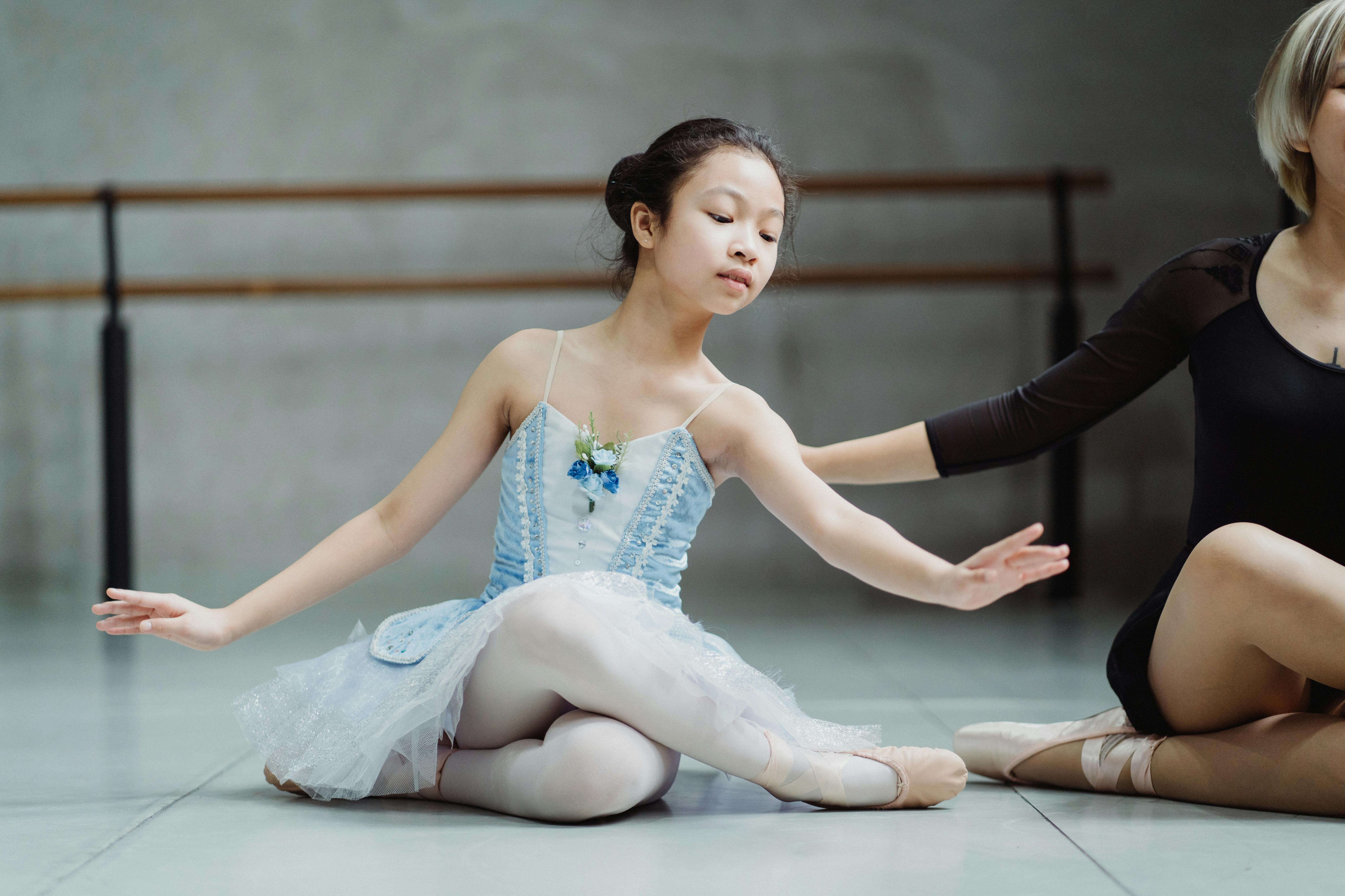 graceful ethnic ballerina learning dance with teacher