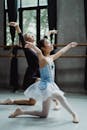 Graceful Asian ballet dancer with girl learning dance