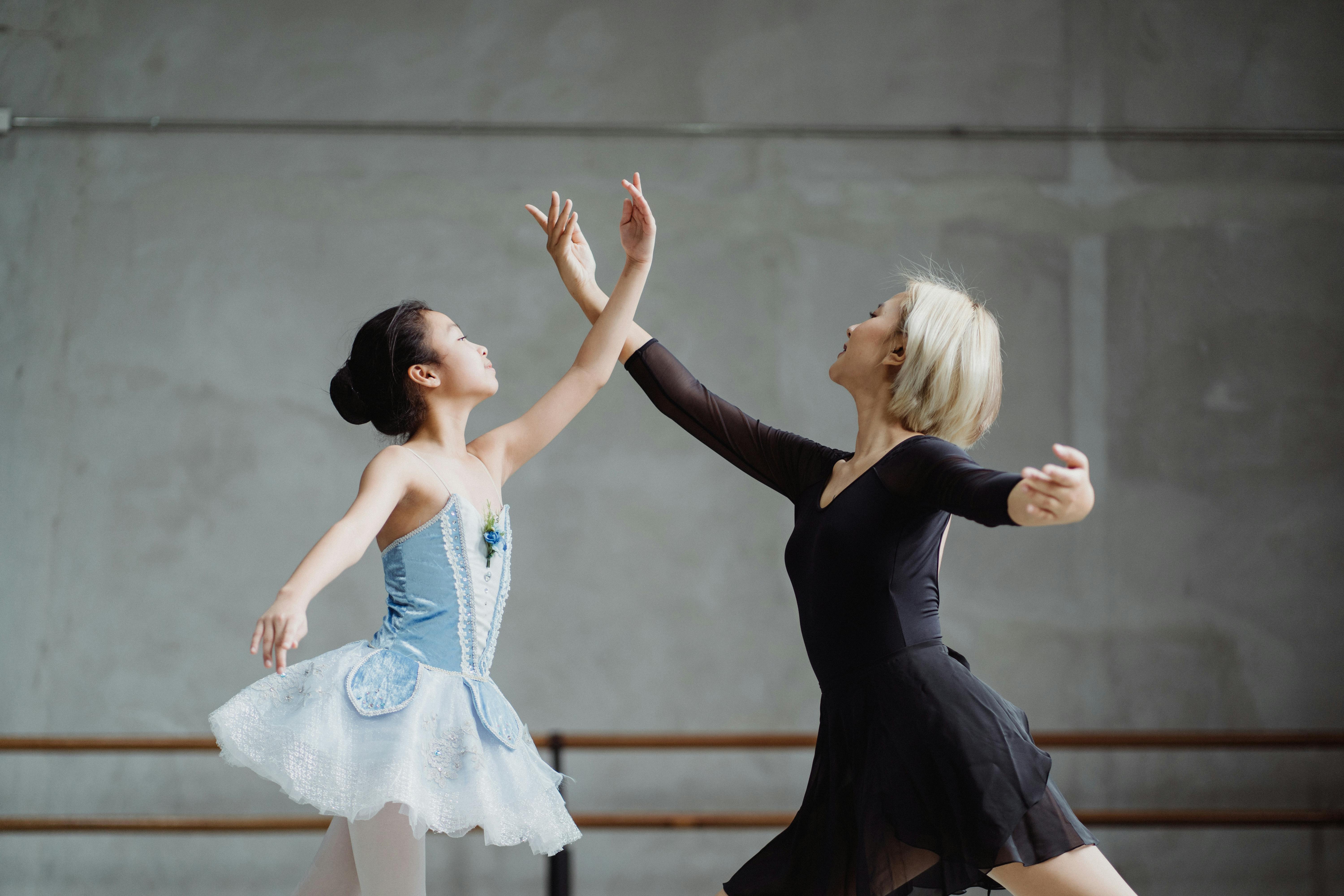 asian ballet teacher dancing with student