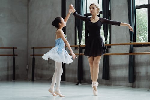 Ballerina with teacher dancing in studio