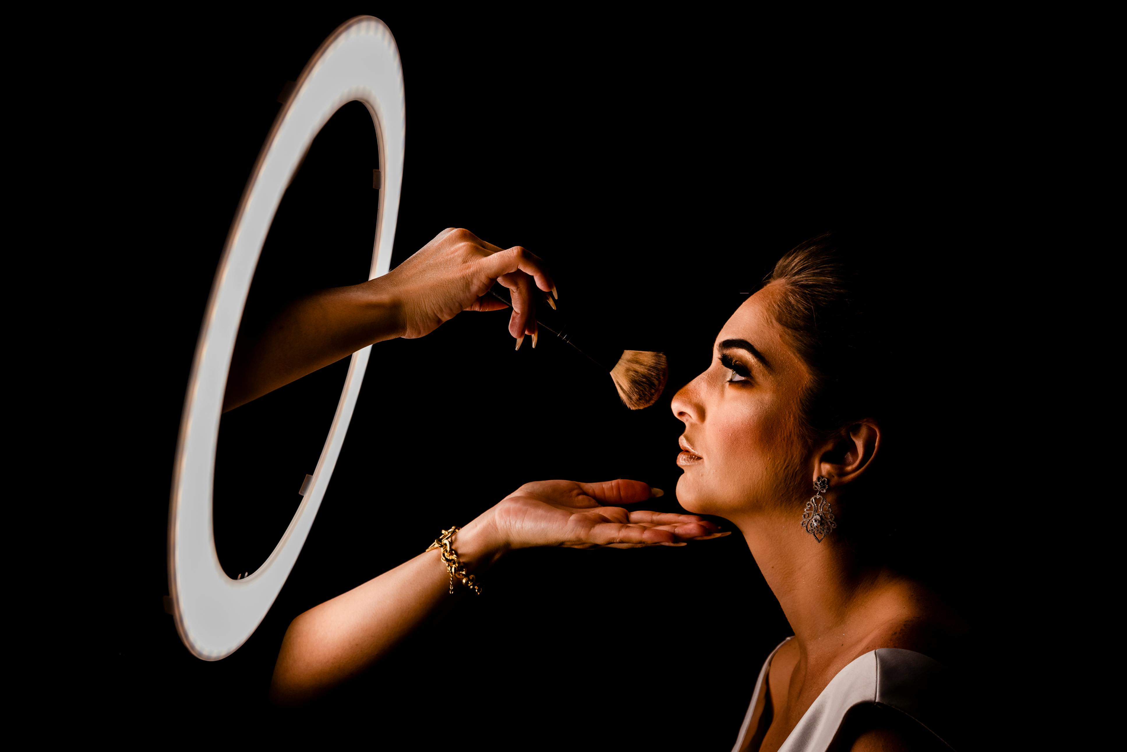 Woman getting ready at a vanity with bright lighting