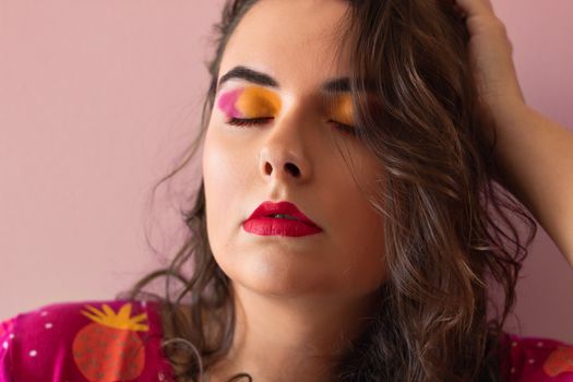 Close-up portrait of a woman with colorful eyeshadow and red lips, exuding elegance and style.
