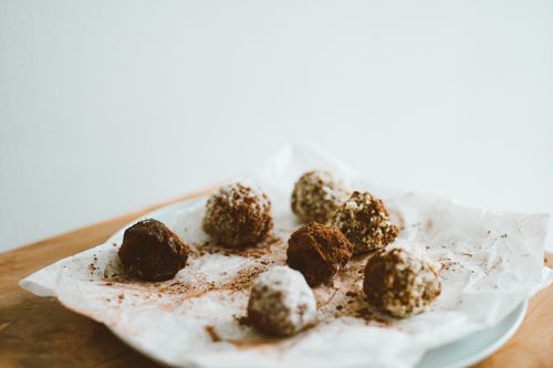 Free Delicious homemade chocolate truffles on a ceramic plate dusted with cocoa and coconut flakes. Stock Photo