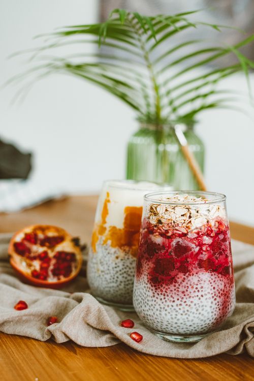 Free Delicious chia pudding with pomegranate and mango toppings in glass jars, perfect for a healthy breakfast. Stock Photo
