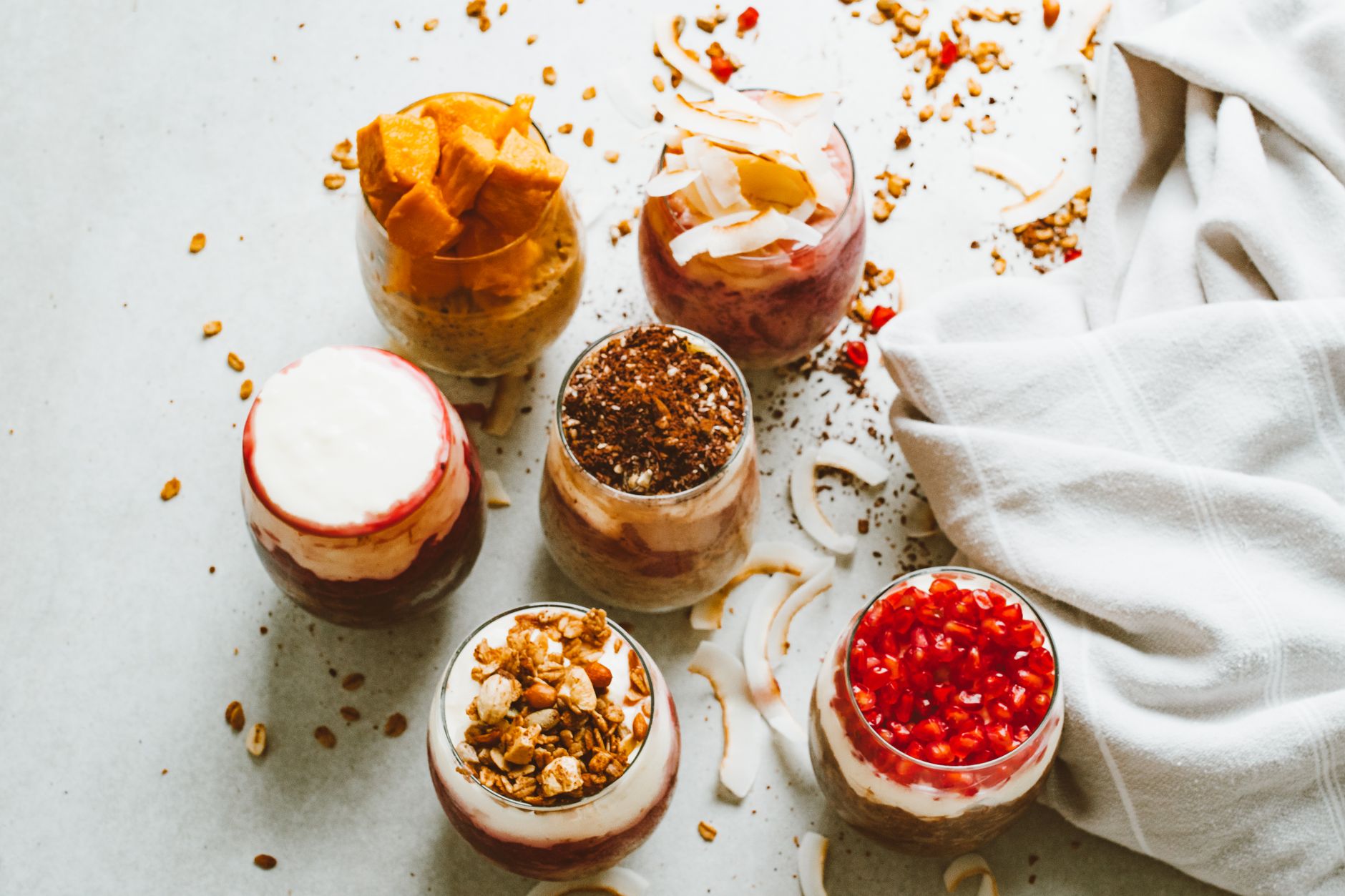 健康飲食不無味:5道簡單美味食譜 Top-down view of assortment of delicious yogurt parfaits topped with fresh fruits and granola.